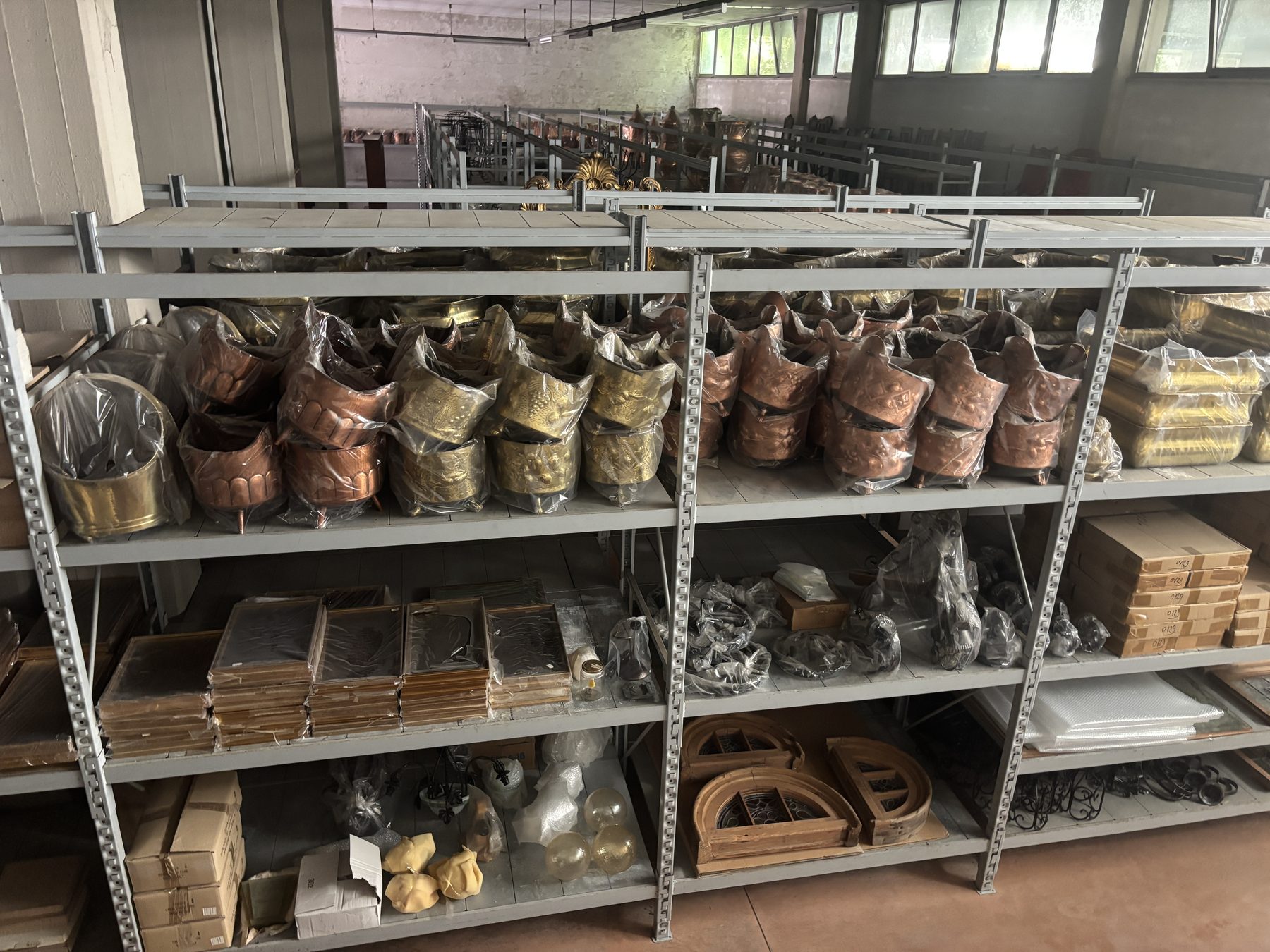 Scaffali con cache-pot e vasellame in rame e ottone