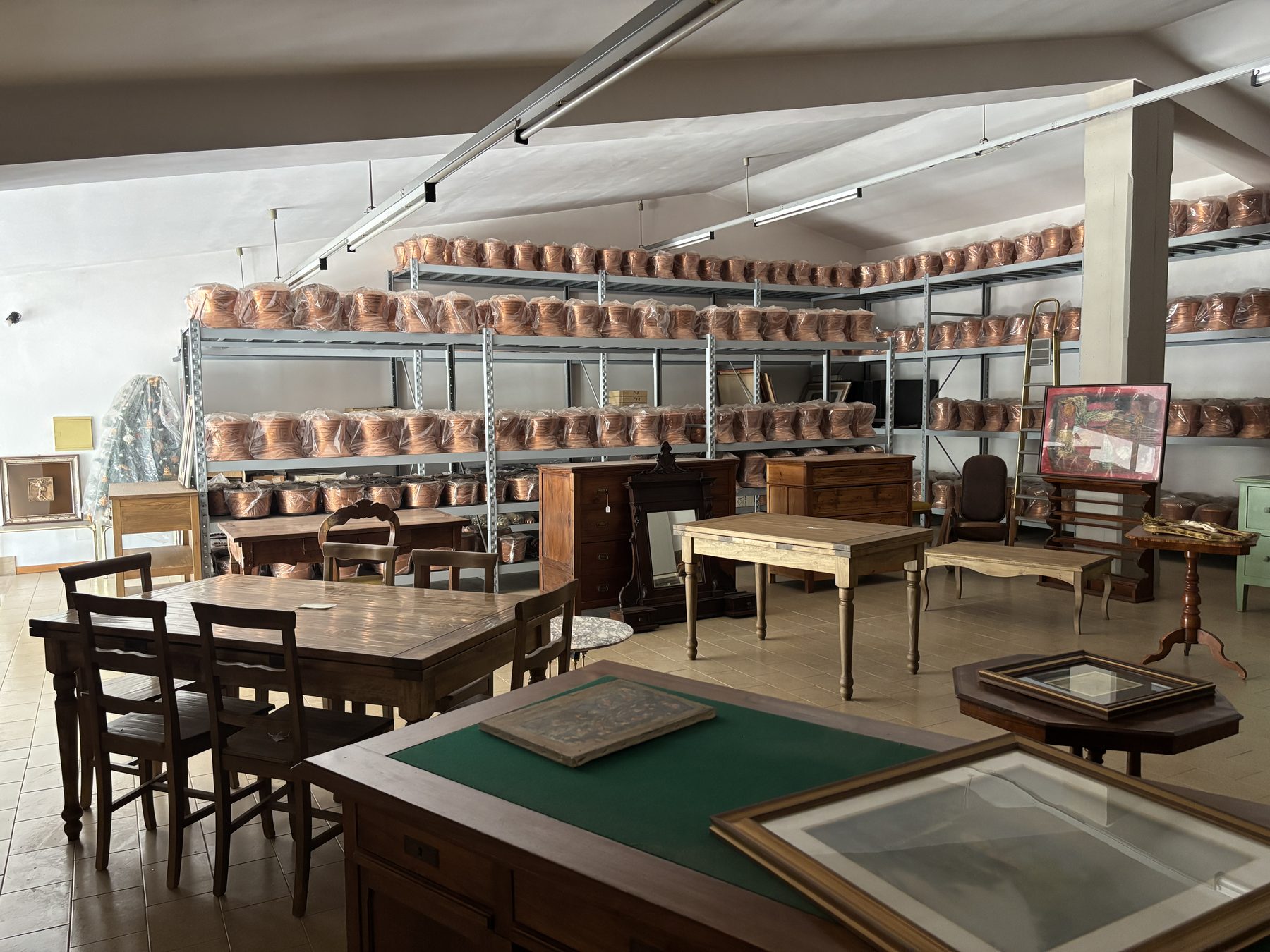 Sala del magazzino con pareti di pentole in rame