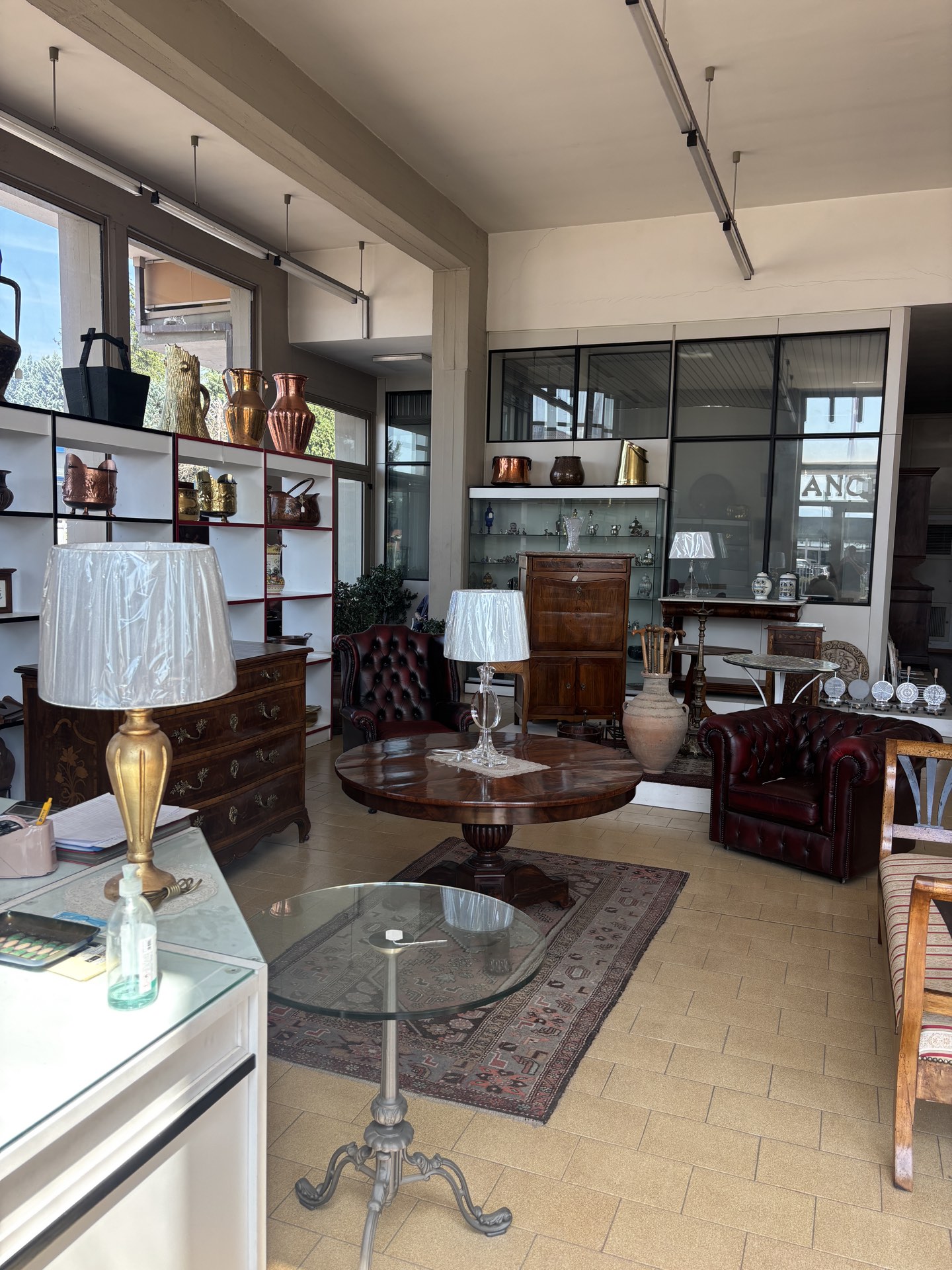 Angolo salotto dello showroom Angelini con poltrone Chesterfield e lampade d'epoca